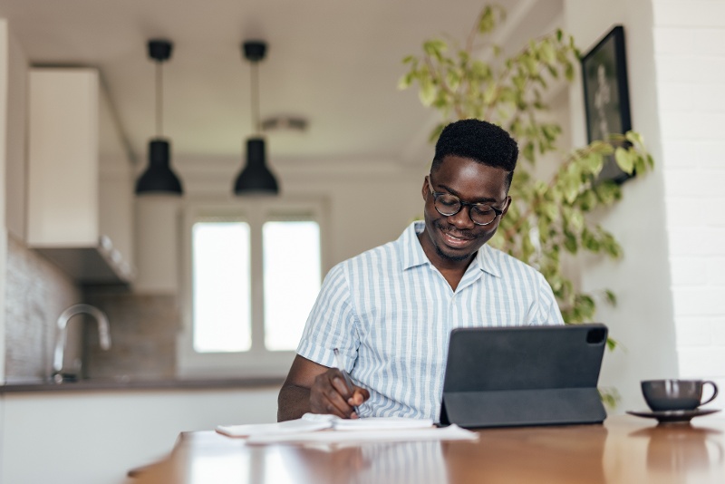 Man smiling at computer during virtual primary care appointment