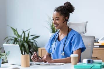 Female healthcare provider using laptop to speak to patient on telemedicine video call