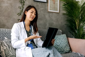 Woman doctor using tablet to speak to patient during a telemedicine appointment