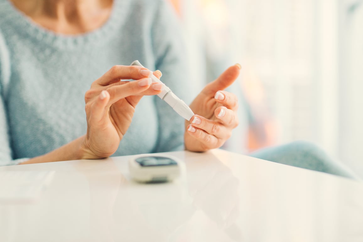 Diabetic woman pricking her finger to test her glucose levels