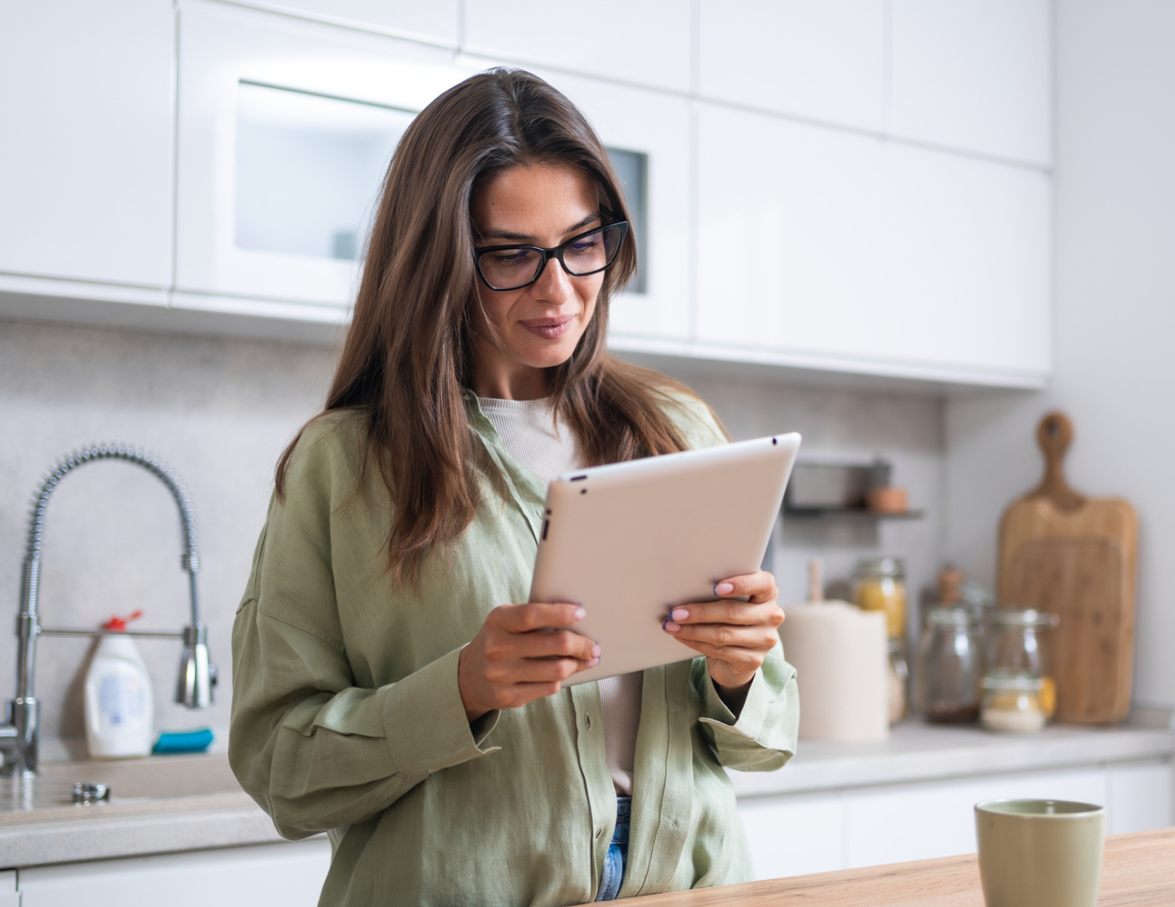 Woman looking at a tablet in kitchen